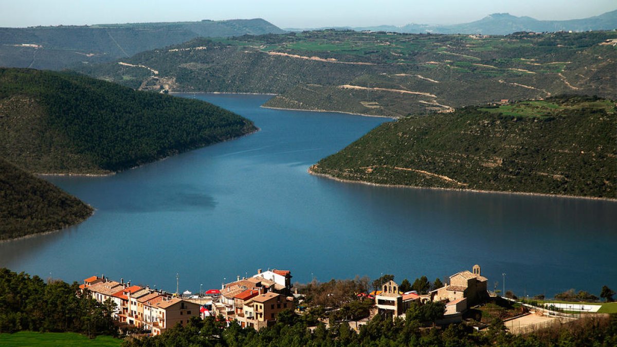 El nou poble de Tiurana i al fons les aigües de l’embassament de Rialb, que commemora el seu 20 aniversari.