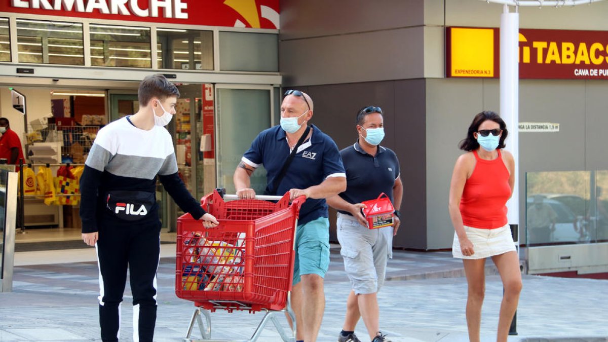 Una familia francesa sale con la compra que hizo ayer en un establecimiento del Pertús.