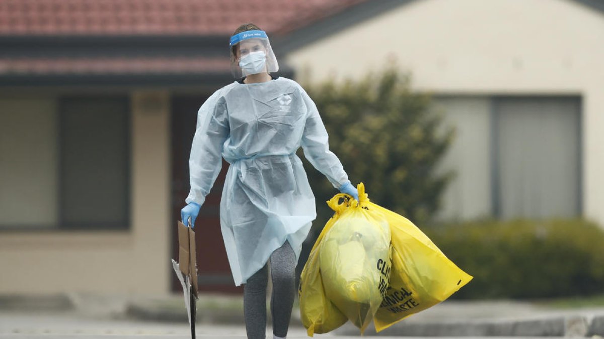 Una sanitaria transporta desechos clínicos en Melbourne.