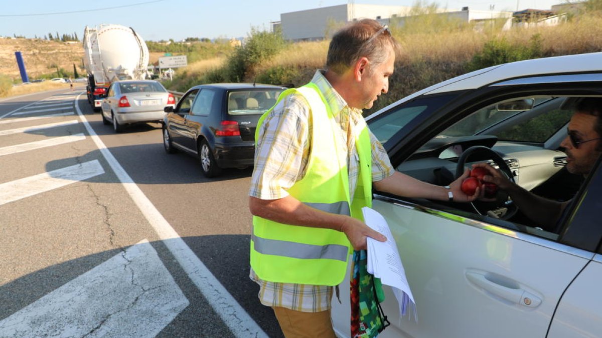 L’alcalde de Bovera donant nectarines a un conductor.