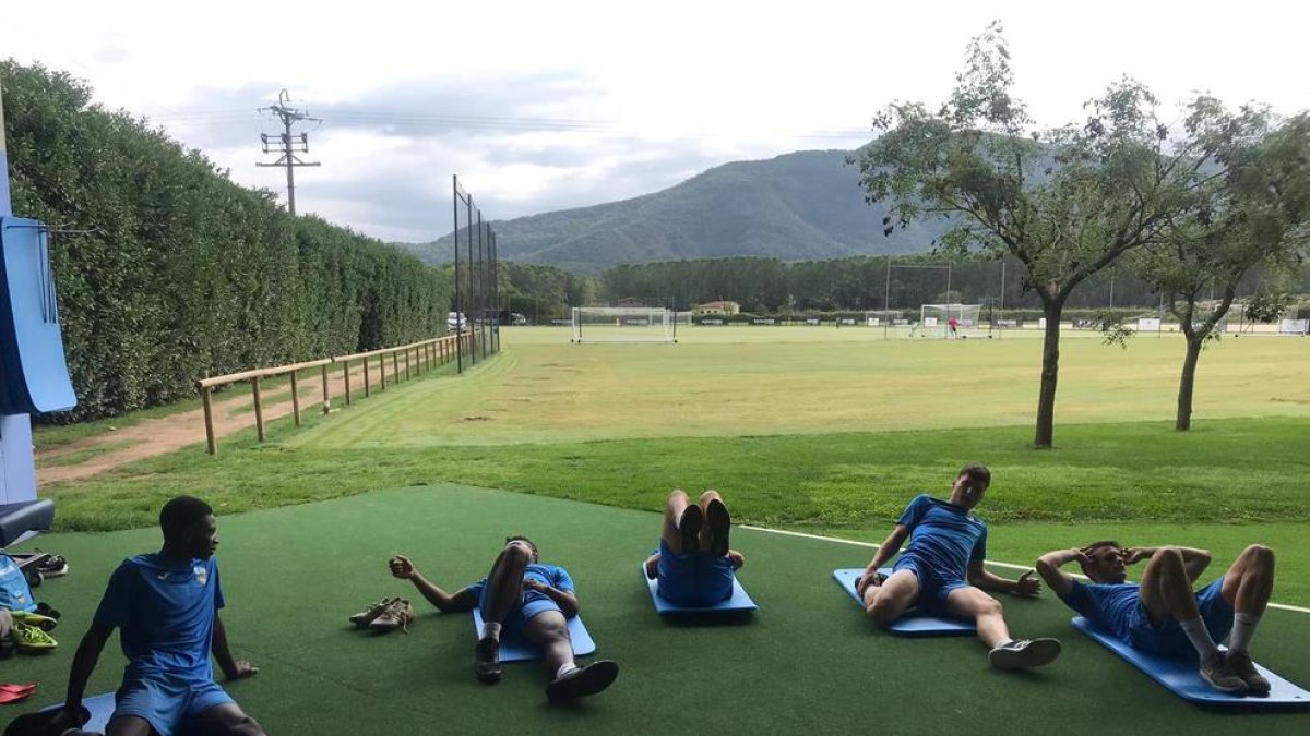Los jugadores del Lleida estiran después del entrenamiento.