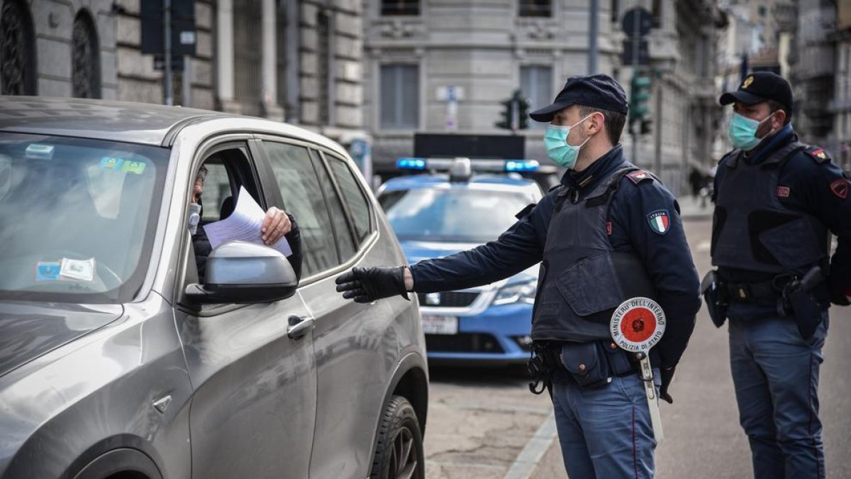 Control de la policia italiana a un vehicle, ahir. Els agents, amb mascareta, guarden les distàncies.