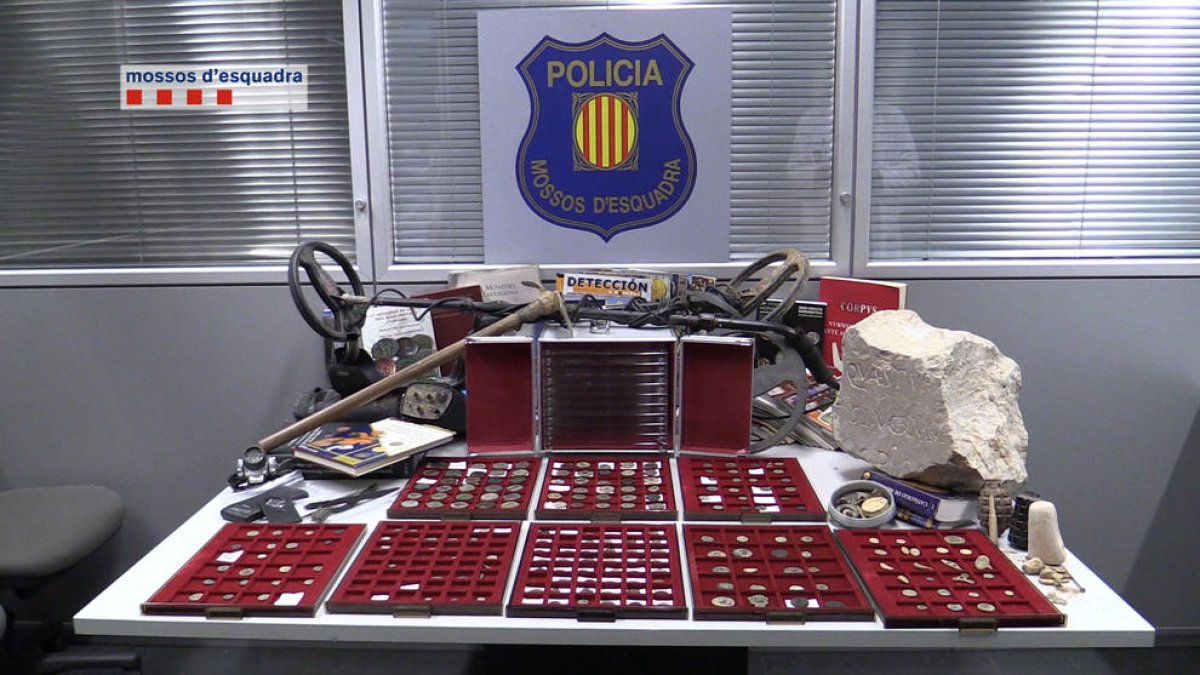 Les monedes i el detector intervinguts pels Mossos d’Esquadra al condemnat.