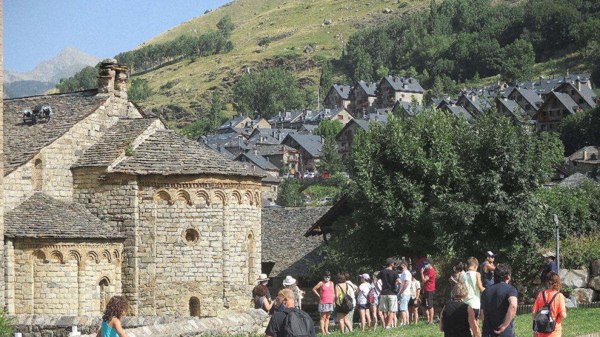 Turistes ahir a Sant Climent de Taüll, el càmping de la Vall d’Àger i un grup de senderistes al pàrquing del Parc Nacional d’Aigüestortes i Estany de Sant Maurici a Espot.