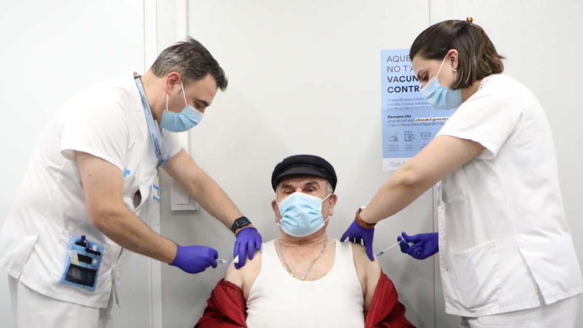 Un hombre recibe la tercera dosis y la vacuna de la gripe.
