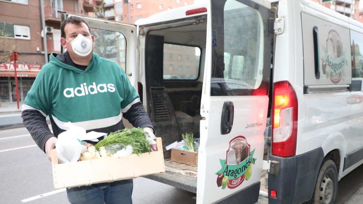 Un repartidor del Grup Aragonés entrega una comanda a domicili de fruites i verdures, ahir.