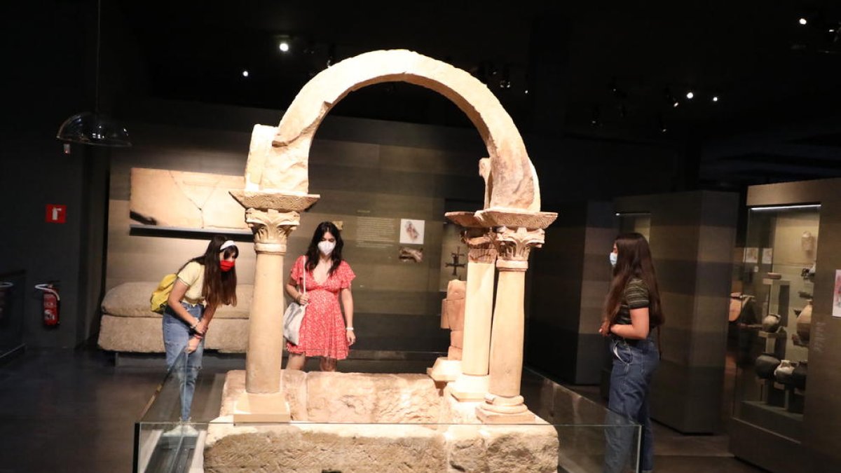 Tres joves ahir davant del baptisteri paleocristià de Bovalar de Seròs, que es conserva al Museu de Lleida.