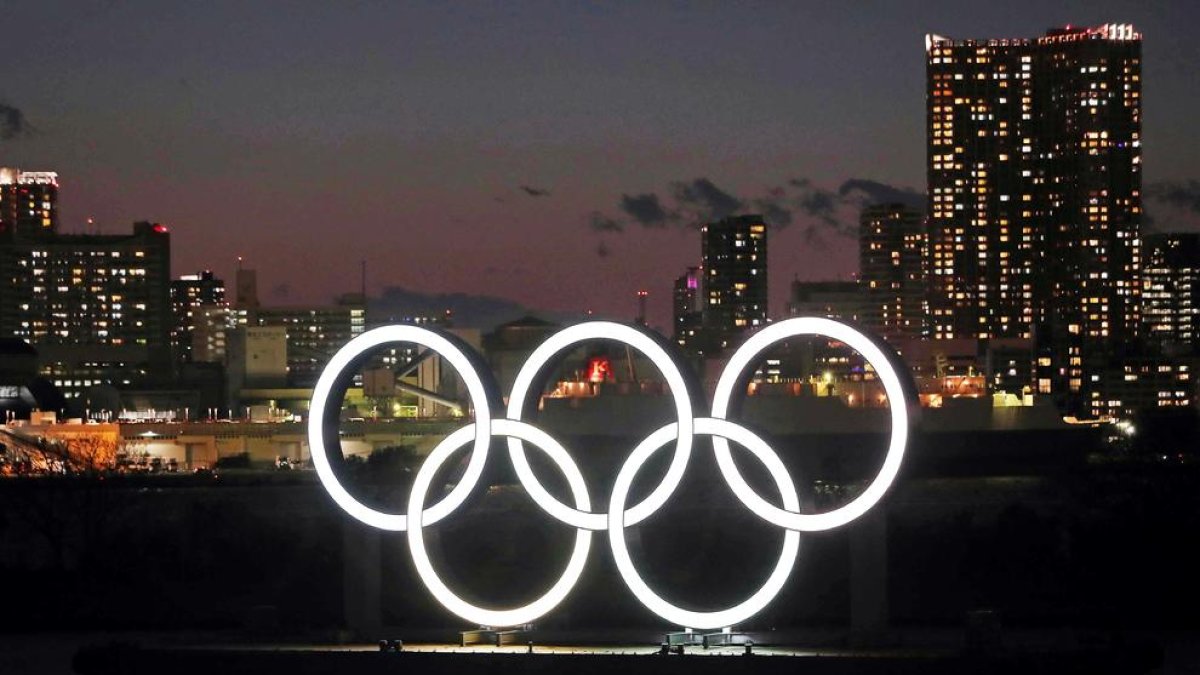 Los aros olímpicos lucen de noche en la bahía de Tokio.