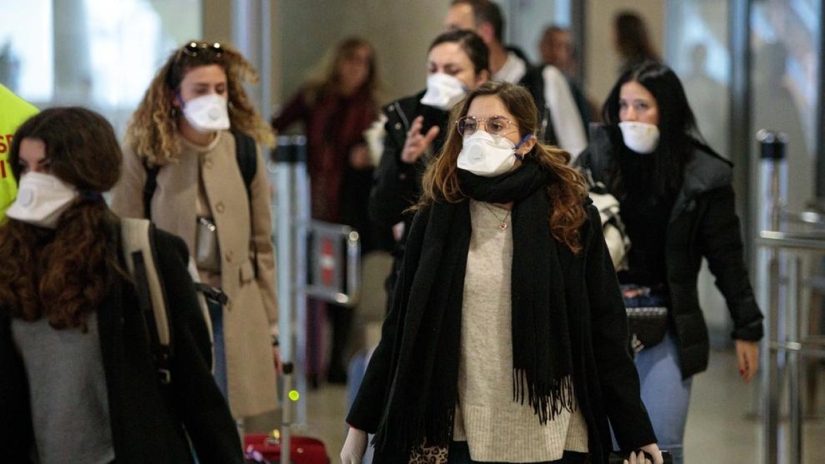 Viatgers procedents d’Itàlia protegits amb màscares a l’arribada a l’aeroport de Manises.