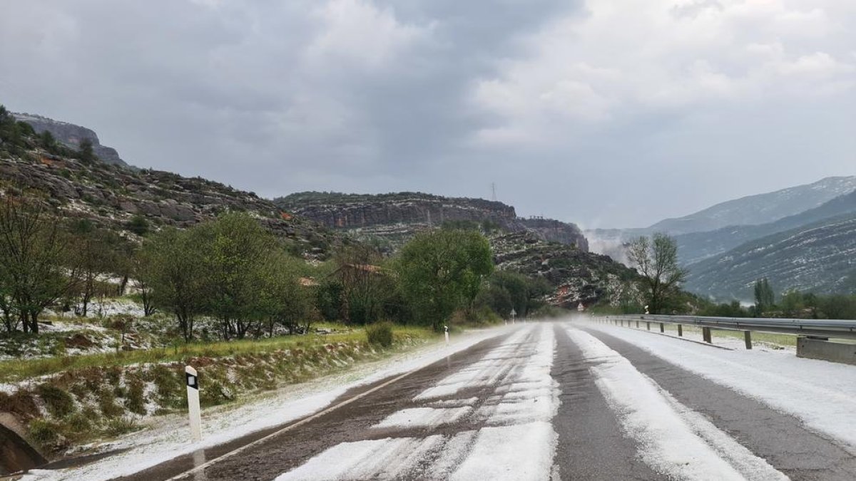 La carretera C-13, entre Pobla de Segur i Gerri de la Sal, coberta de pedra en el marc d'una tempesta d'estiu.