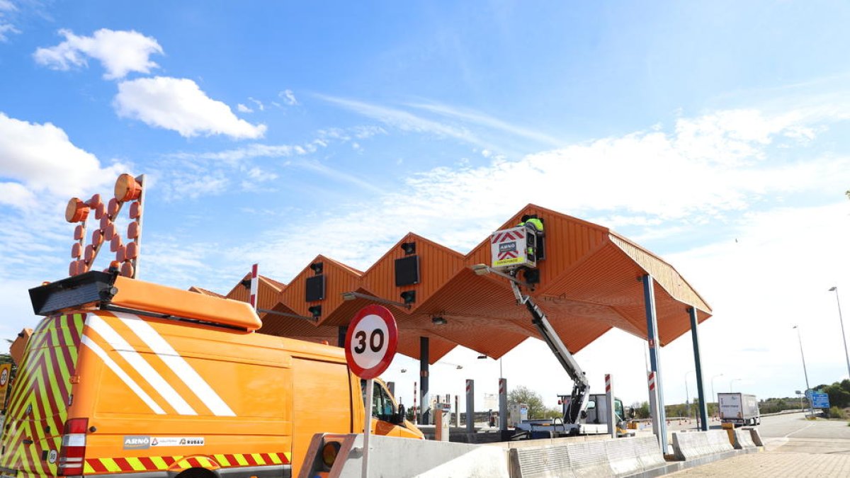 Operaris retirant ahir peces de les casetes de peatge de l’autopista a l’accés de Lleida ciutat.