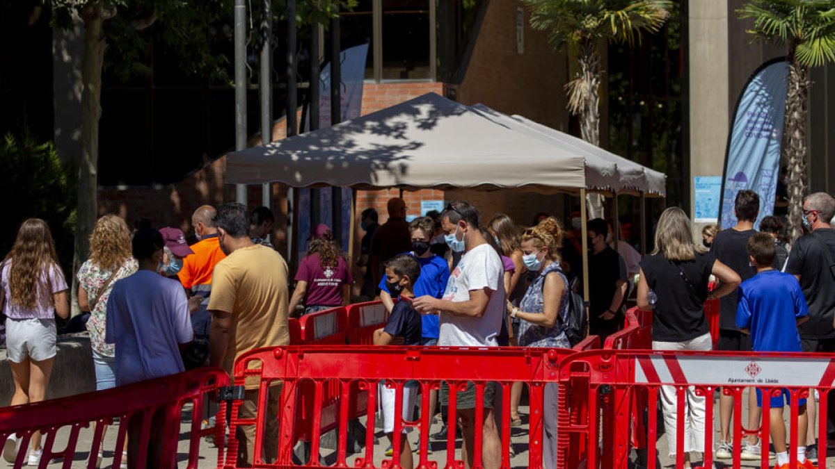 Cues davant del pavelló Onze de Setembre de Lleida per rebre la vacuna.