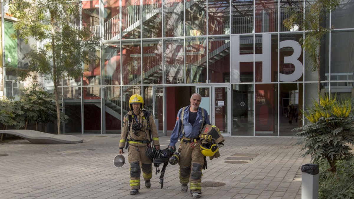 Dos bomberos saliendo ayer del edifico H3 donde hay el laboratorio en el que hubo la explosión. 