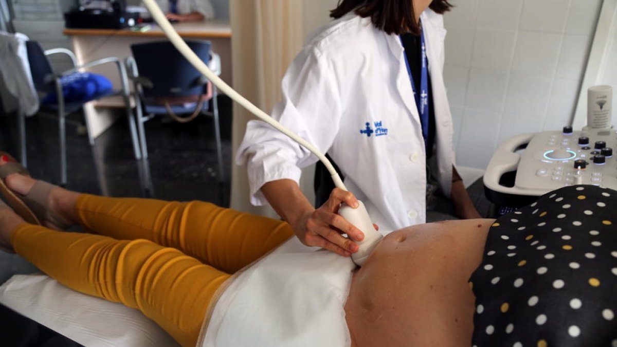 Una doctora hace una ecografía a una mujer embarazada, que participa en el ensayo clínico de la vacuna de Pfizer de la covid-19 en este colectivo, en el Hospital Vall d'Hebron