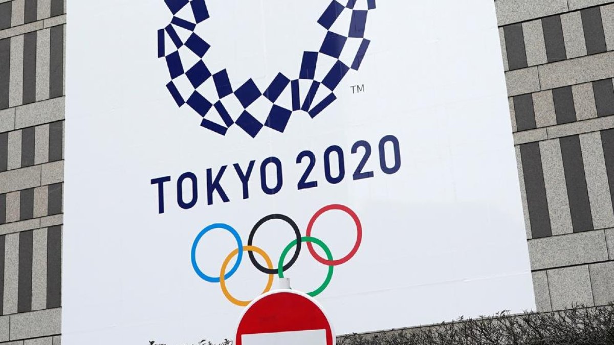 Un senyal de prohibit el pas davant d’un cartell dels Jocs Olímpics.