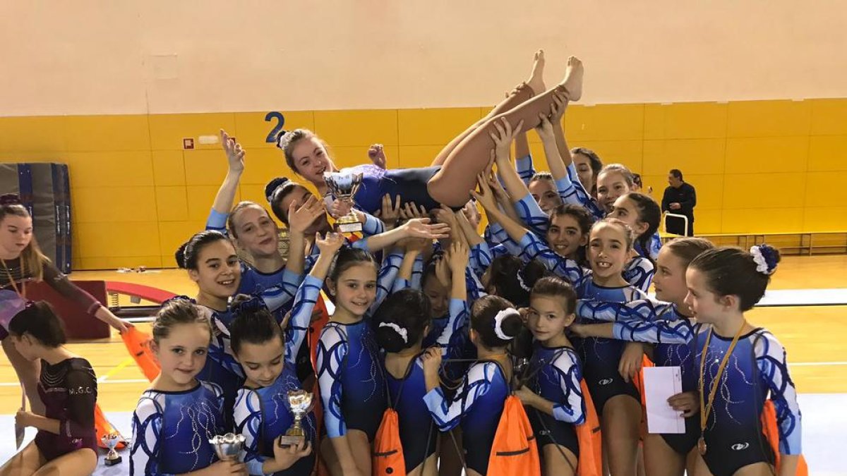 Las gimnastas del Club Gimnàstic FEDAC Lleida levantan a Àngela Mora tras su participación en el Torneo de Esplugues.
