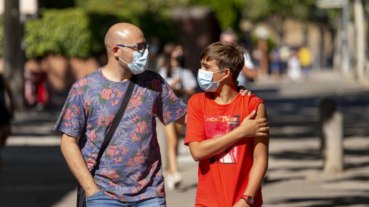 Pau Asensio, de 13 anys, ahir amb el seu pare després de rebre la vacuna a Lleida ciutat.