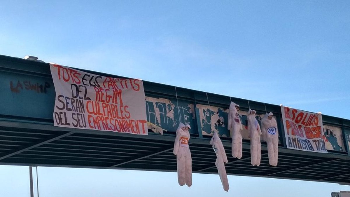 Los muñecos que aparecieron ayer colgados en el puente peatonal de acceso al Camp Escolar