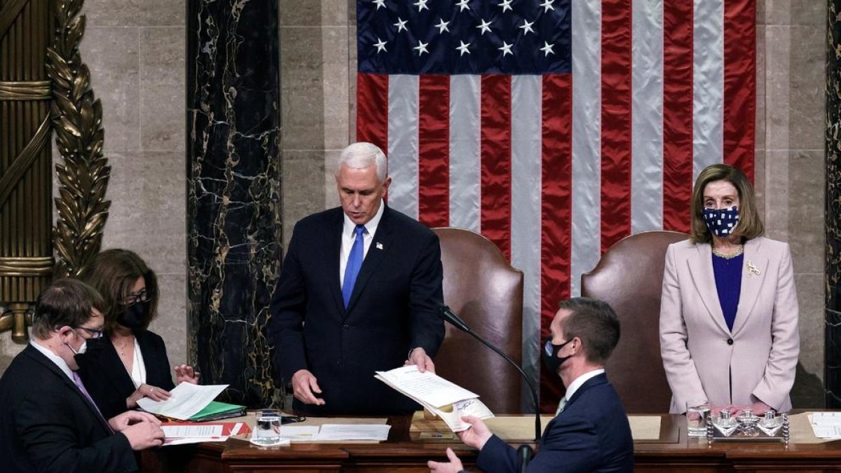 Pence da lectura en el Capitolio al acta que confirma a Biden como presidente junto a Nancy Pelosi.