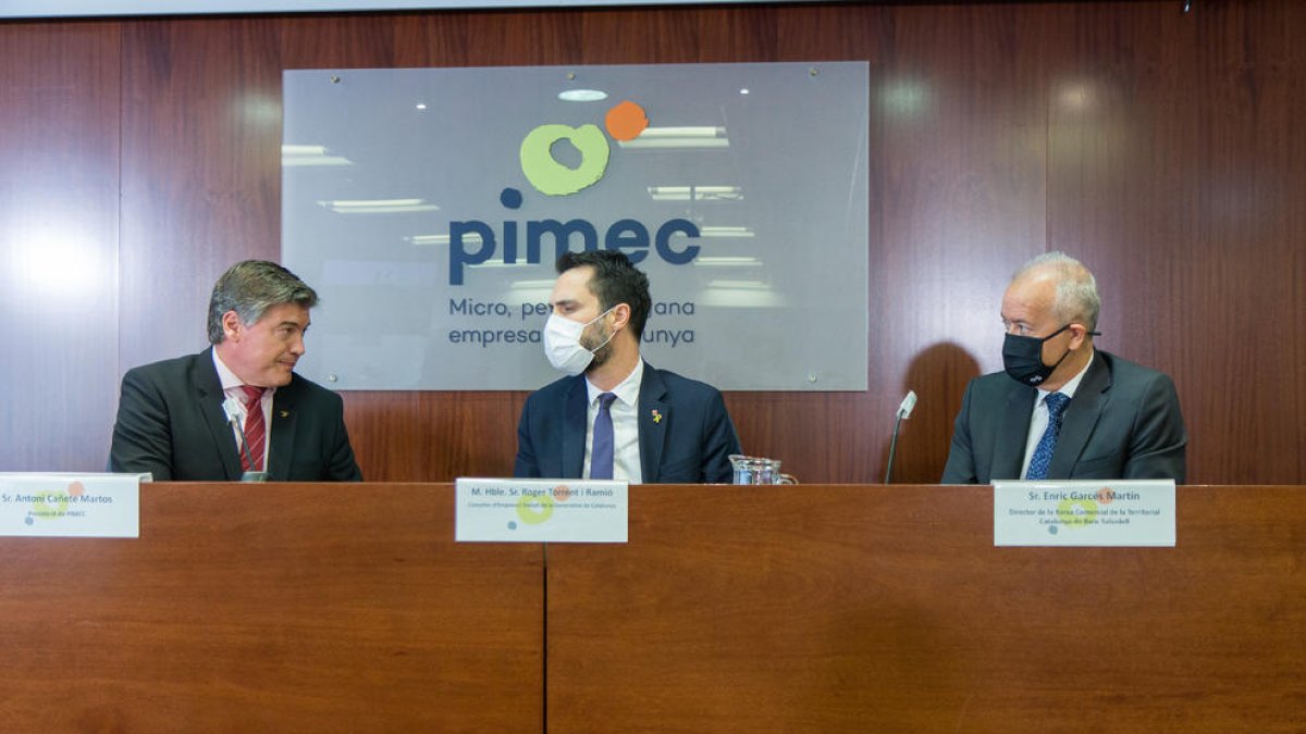 Antoni Cañete conversa con el conseller Roger Torrent y Enric Garcés, ayer durante la presentación.