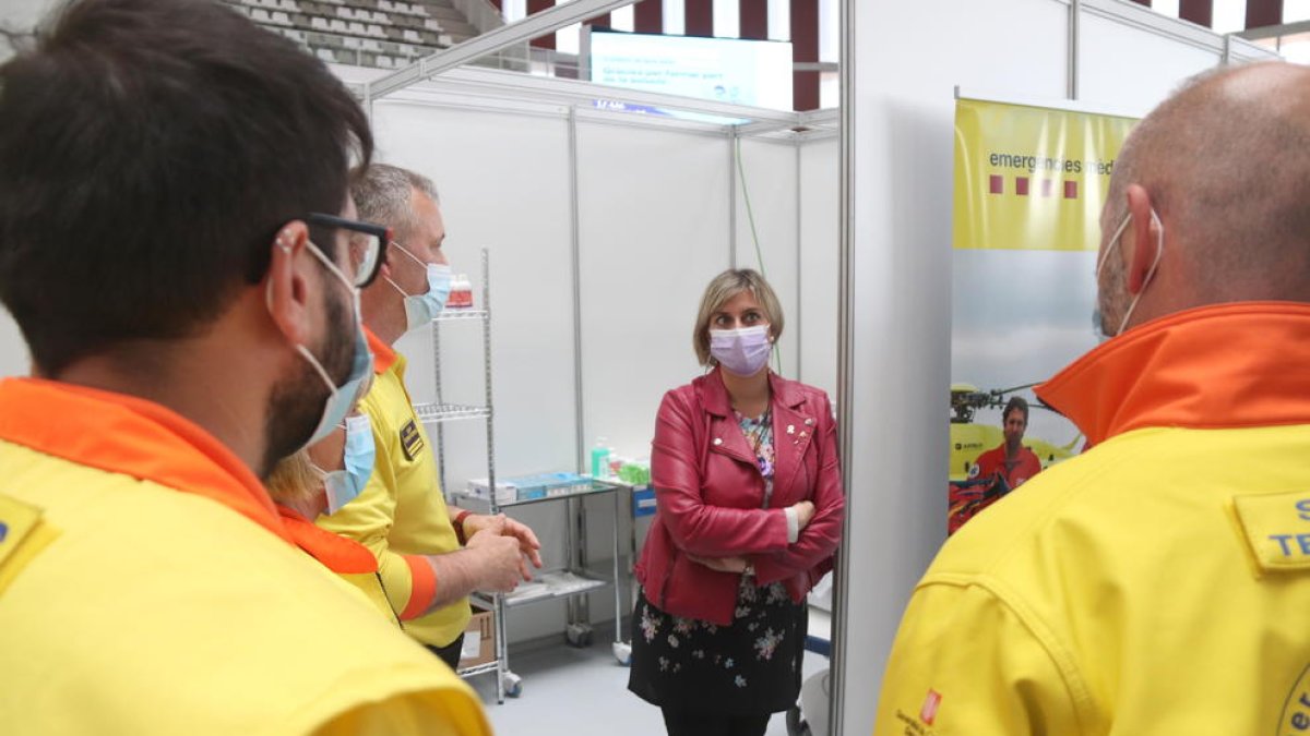 La consellera de Salud, Alba Vergés, conversando con sanitarios en el punto de vacunación masiva del Palau d'Esports Catalunya de Tarragona.