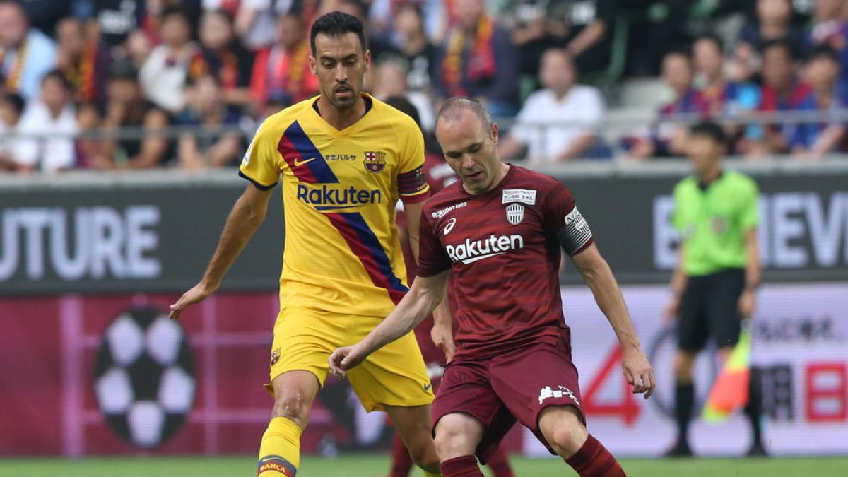 Andrés Iniesta, dels millors del partit, controla la pilota davant de la pressió de Sergio Busquets.