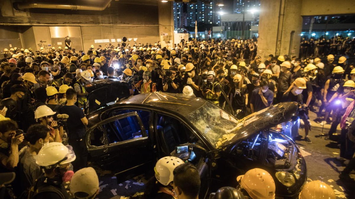 Un cotxe destrossat durant els enfrontaments entre policia i manifestants a Hong Kong.