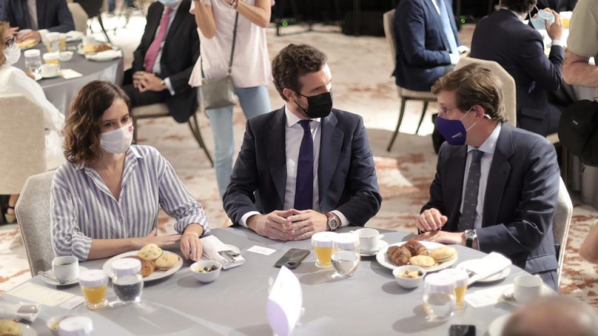 Casado, flanqueado ayer por la presidenta y el alcalde madrileño en un desayuno-coloquio.