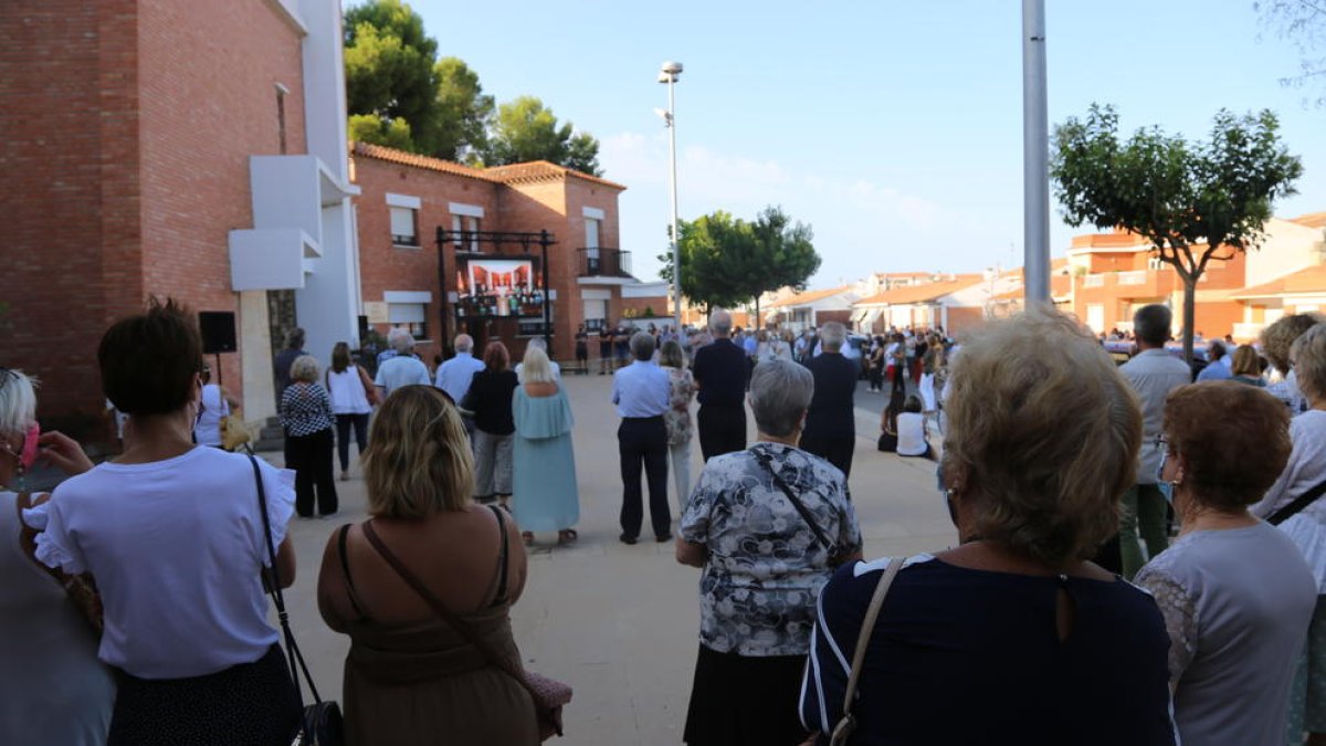 Desenes de veïns van seguir el funeral des del carrer.