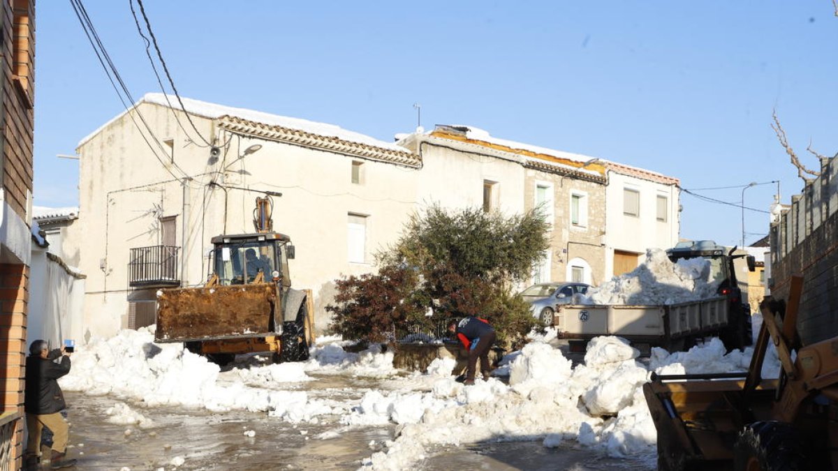 Vecinos colaborando ayer por la tarde en la limpieza de la nieve acumulada en las calles de Aspa.