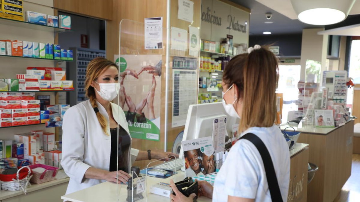 Una ciutadana compra en una farmàcia de Lleida.