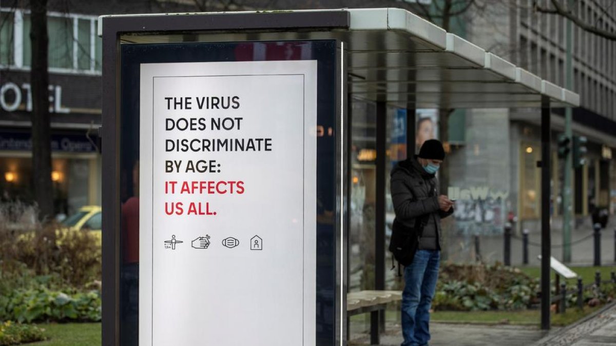 Un cartell adverteix del risc de contagi per a qualsevol edat, en una parada d’autobús a Berlin.