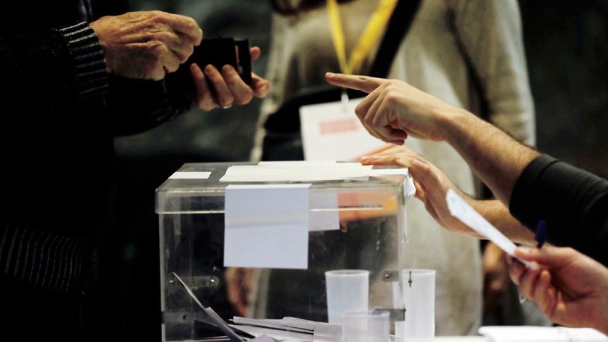 Una persona se acredita para votar en un colegio electoral de Ciutat Vella de Barcelona