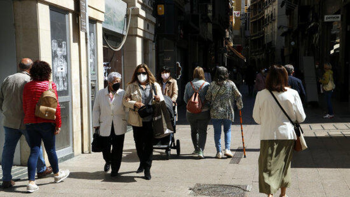 Gent passejant per l'Eix Comercial de Lleida amb mascareta.