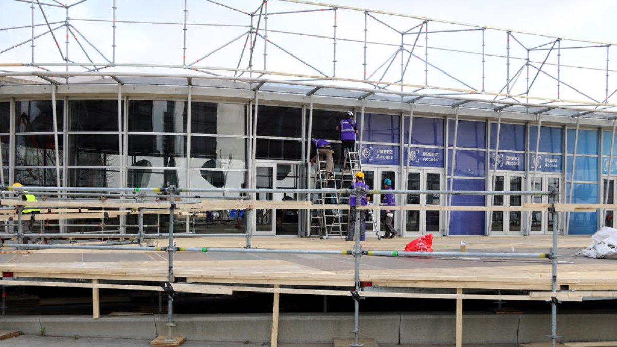 Imagen de operarios montando la entrada del MWC en Fira Gran Via, el 11 de febrero de 2020.