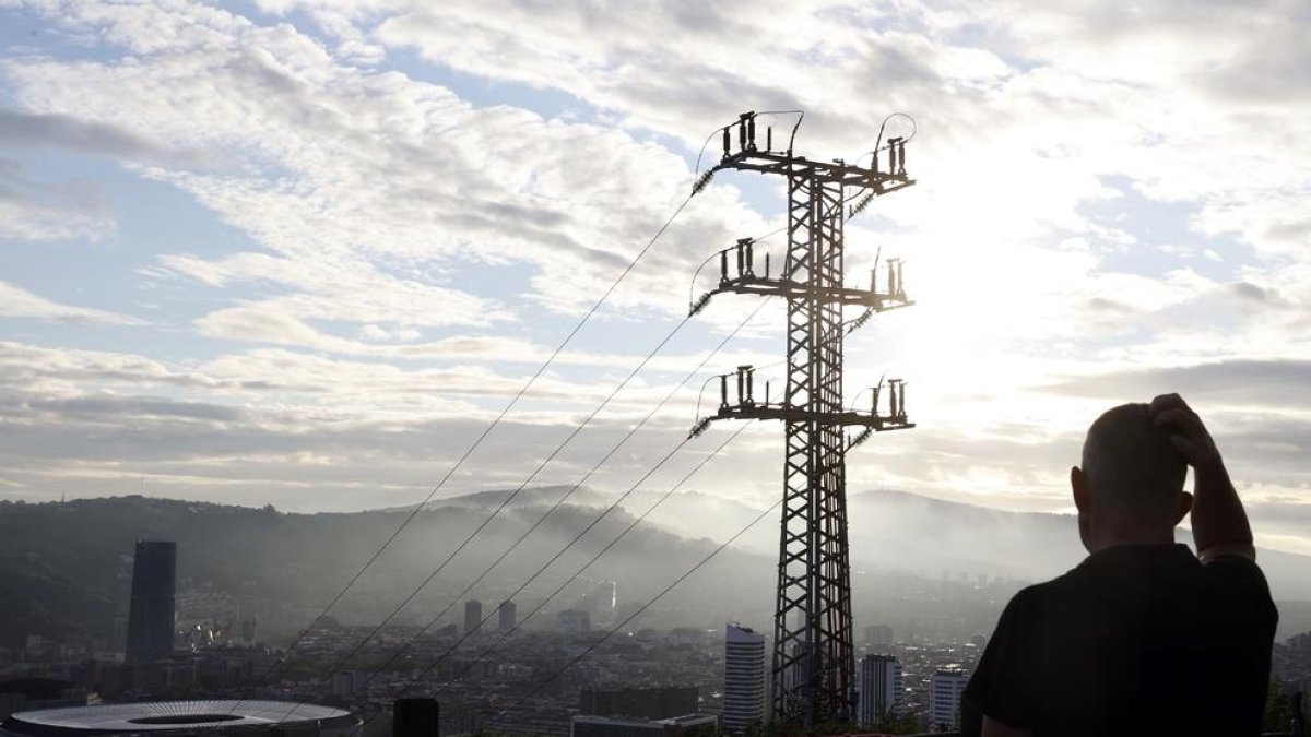 Una persona observa el cableado con el que Red Eléctrica transporta la energía en Bilbao.