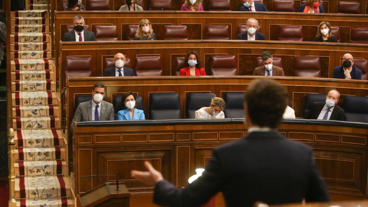 Pedro Sánchez y Pablo Casado, de espaldas, durante su enfrentamiento de ayer en el Congreso.