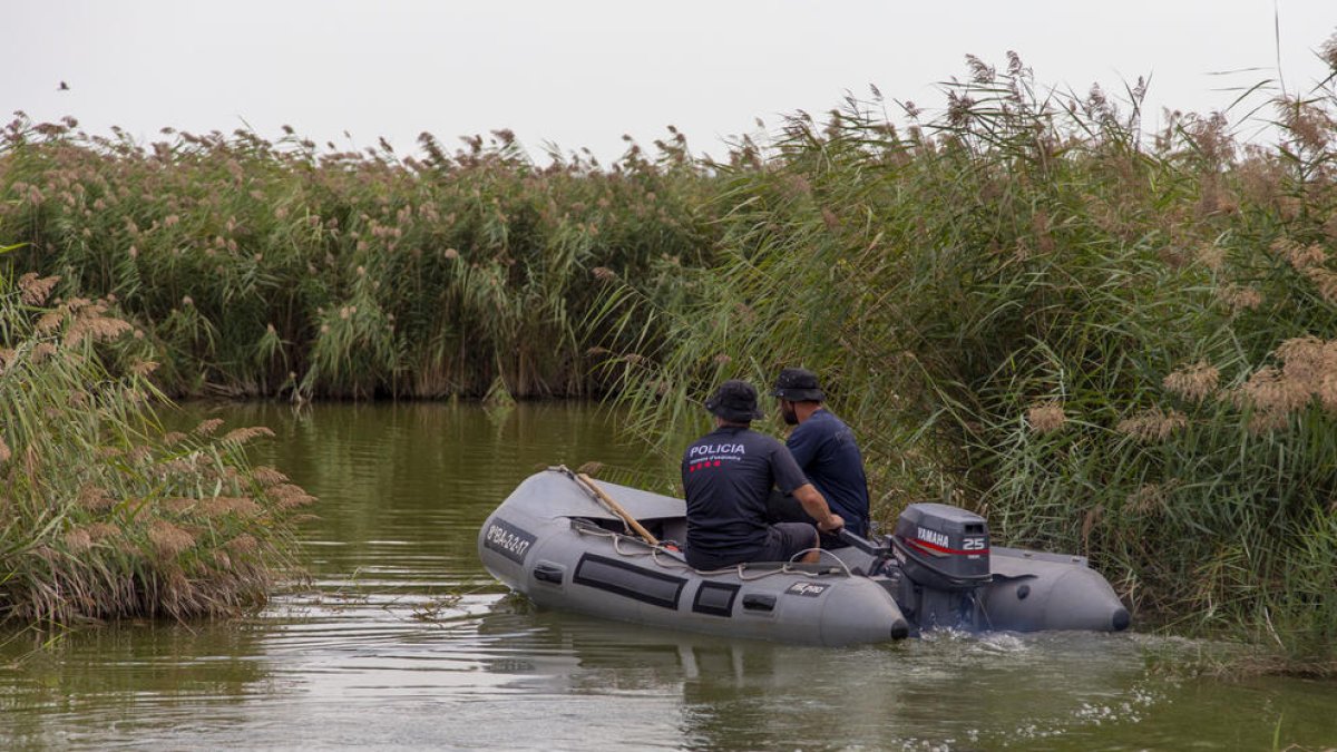 Agentes de los Mossos ayer al mediodía con una lancha en el pantano de Utxesa. 