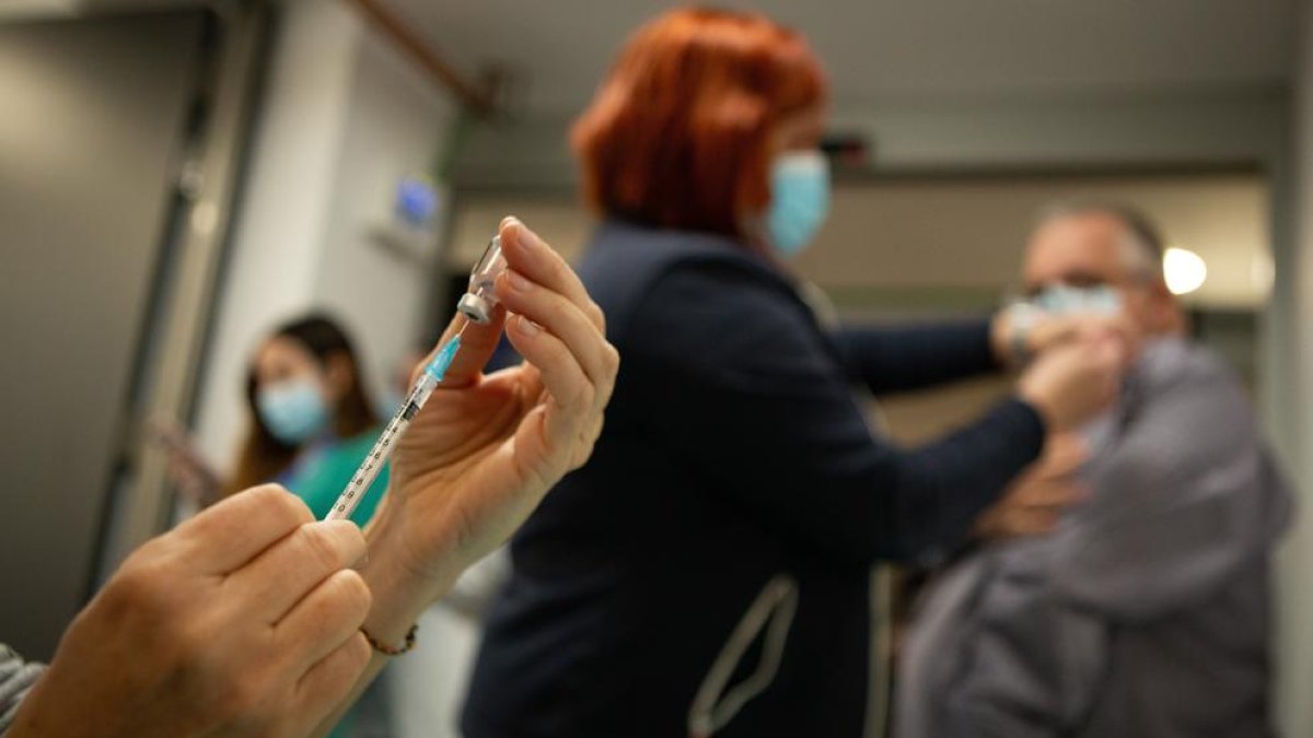 Professionals sanitàries preparen i administren la vacuna de covid-19 als seus companys a l'Hospital Vall d'Hebrón de Barcelona.