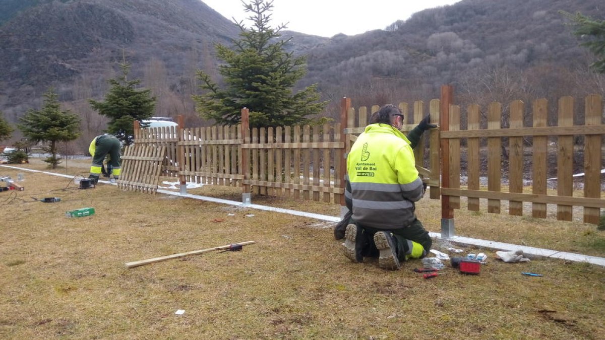 Els operaris instal·len la tanca perimetral.