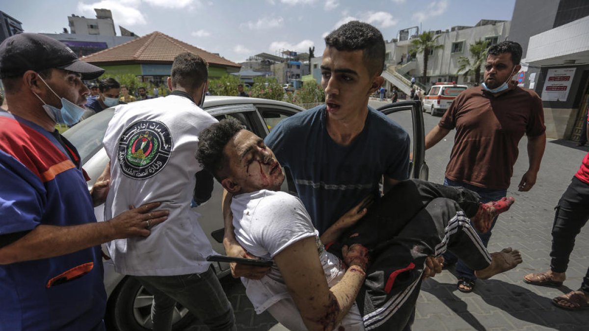 Un joven palestino traslada a un herido por los bombardeos israelíes en la ciudad de Gaza.