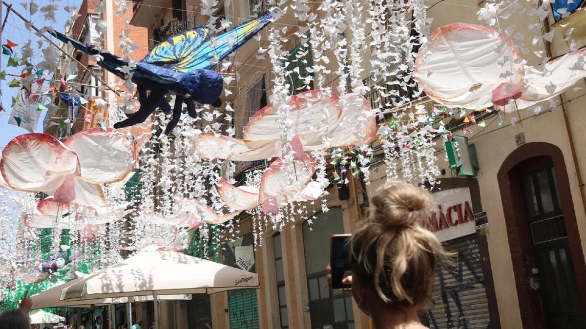 Una visitant fotografia la decoració del carrer Verdi de Gràcia.
