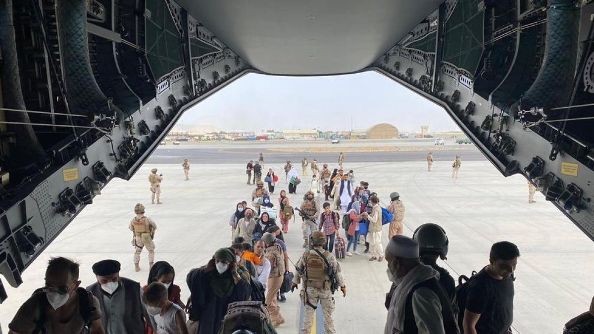Primeros repatriados hacia España, ayer, subiendo a un avión en el aeropuerto de Kabul.