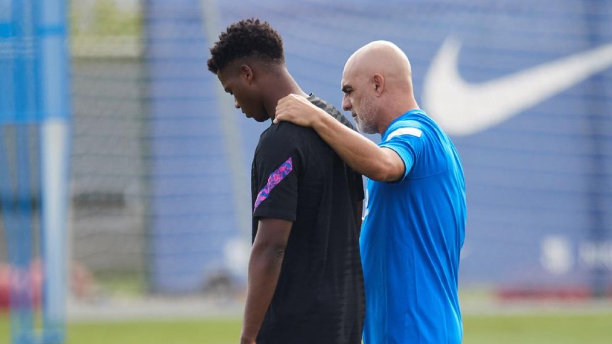 Ansu Fati ayer durante una pausa del entrenamiento junto al recuperador físico Juanjo Brau.