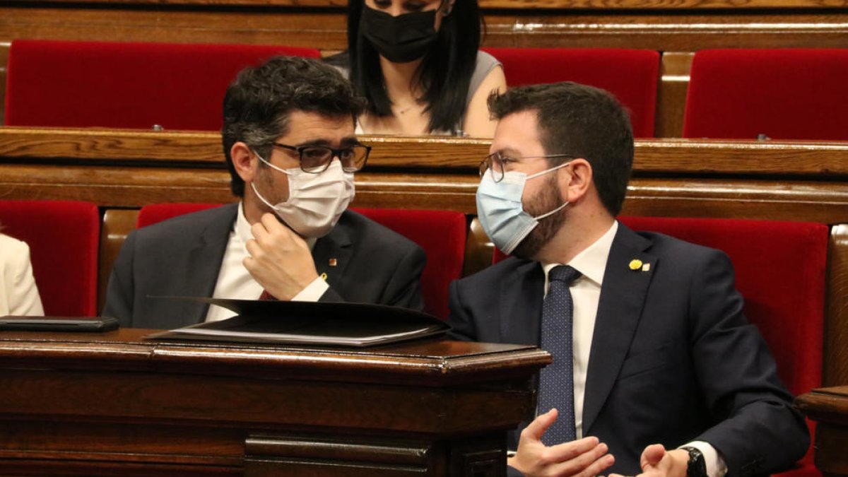 El presidente del Govern, Pere Aragonès, conversa con el vicepresidente, Jordi Puigneró, durante el pleno en el Parlament.