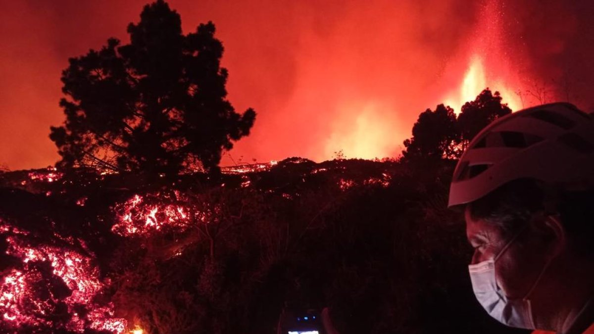 Un treballador de l'Institut Vulcanològic de les Canàries pren la temperatura d'un riu de lava.