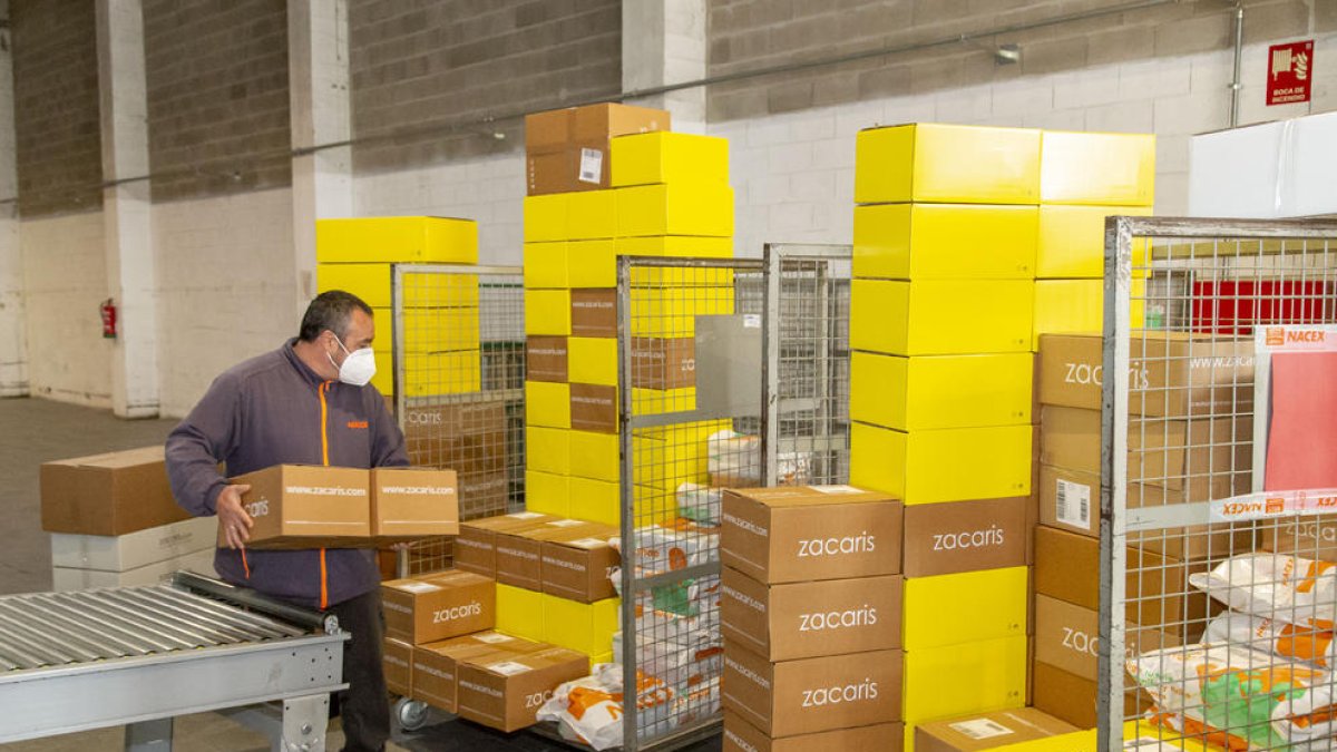 Un trabajador de Nacex Lleida apila unas cajas para llevarlas a una furgoneta y entregarlas, ayer. 