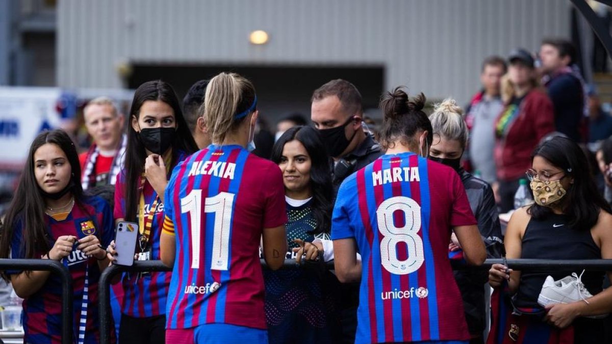 Alexia Putellas i Marta Torrejón firmen autògrafs a les aficionades després del partit a Portland.