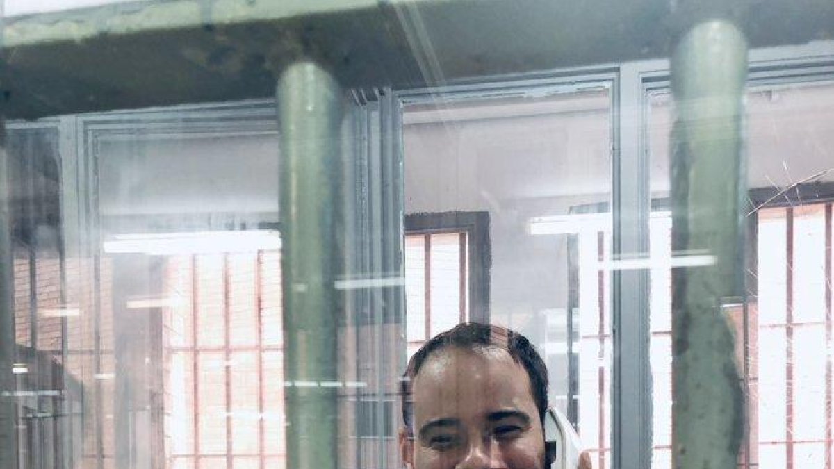 El raper Pablo Hasel parlant a través d'un telèfon en una de les cabines de visita de la presó de Ponent.