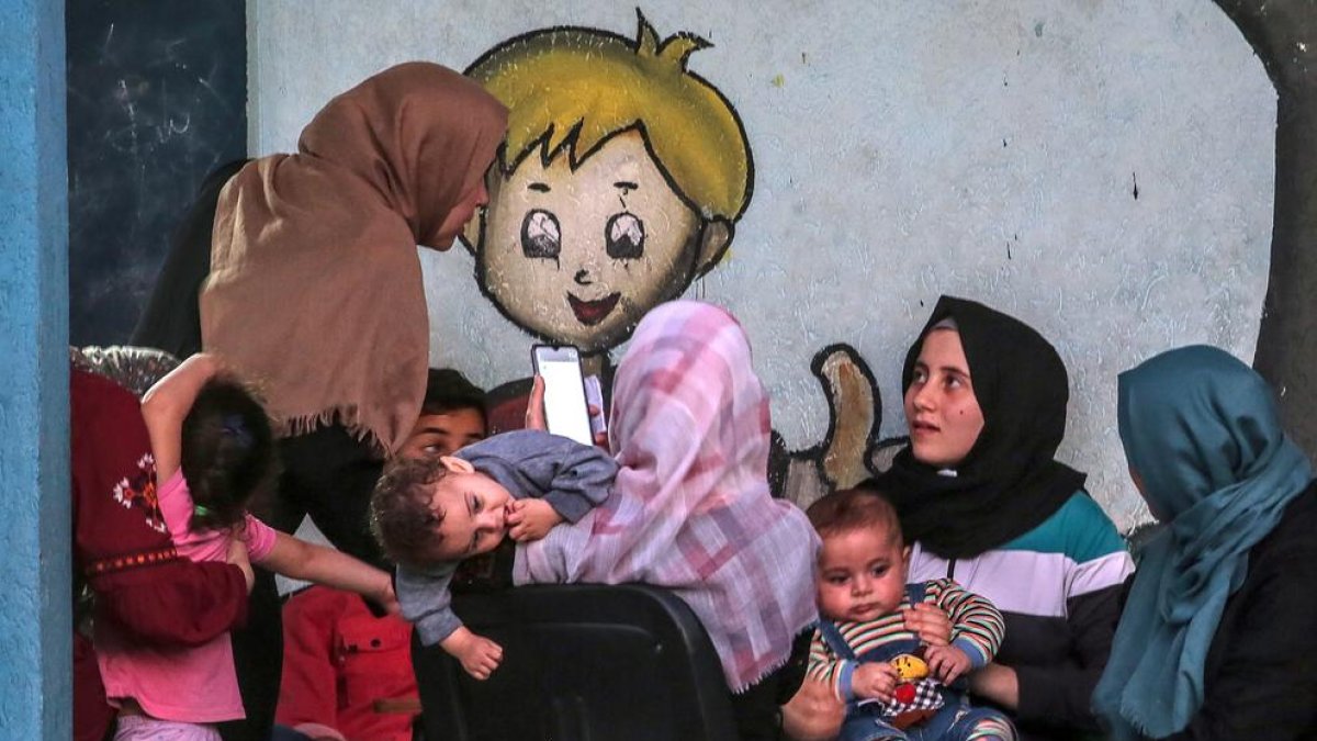 Palestines i els seus fills refugiats en una escola de l’ONU.